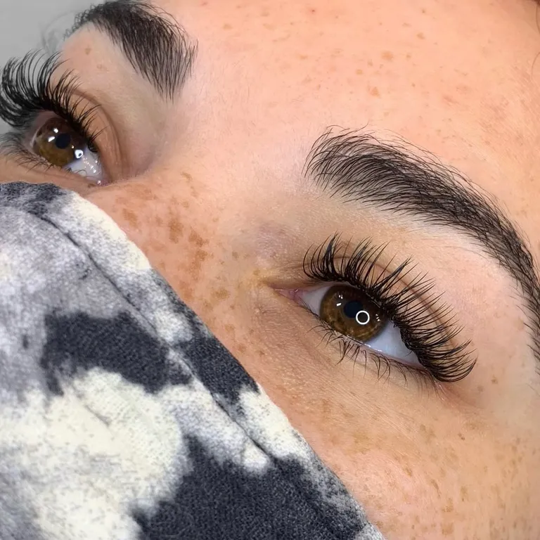 Close-up of a classic eyelash extension set with individually defined black lashes and a soft outer-corner curl by Made by Marissa.