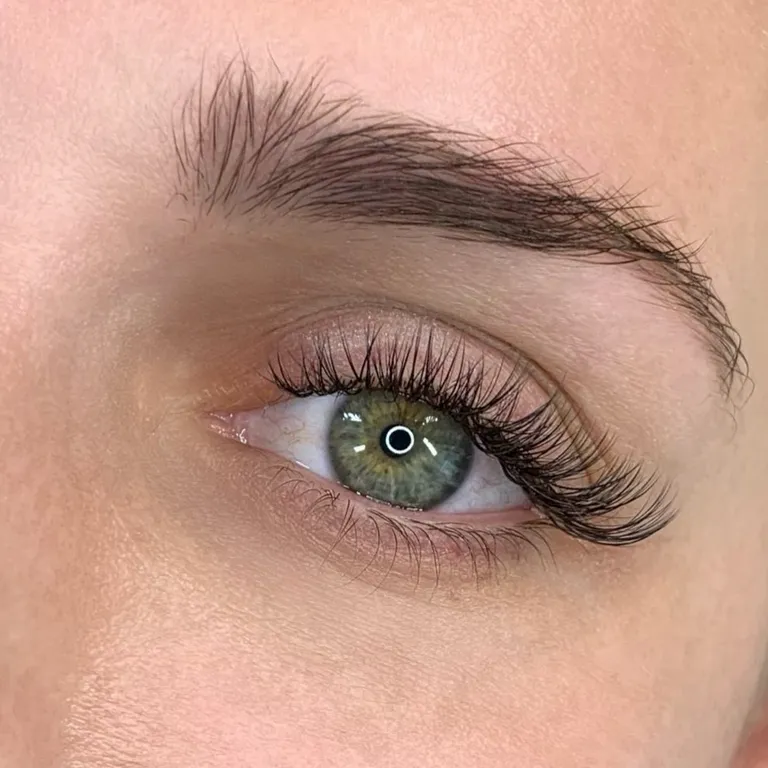Close-up of a green eye wearing a lightweight hybrid eyelash extension set with a gently elongated outer corner by Made by Marissa.