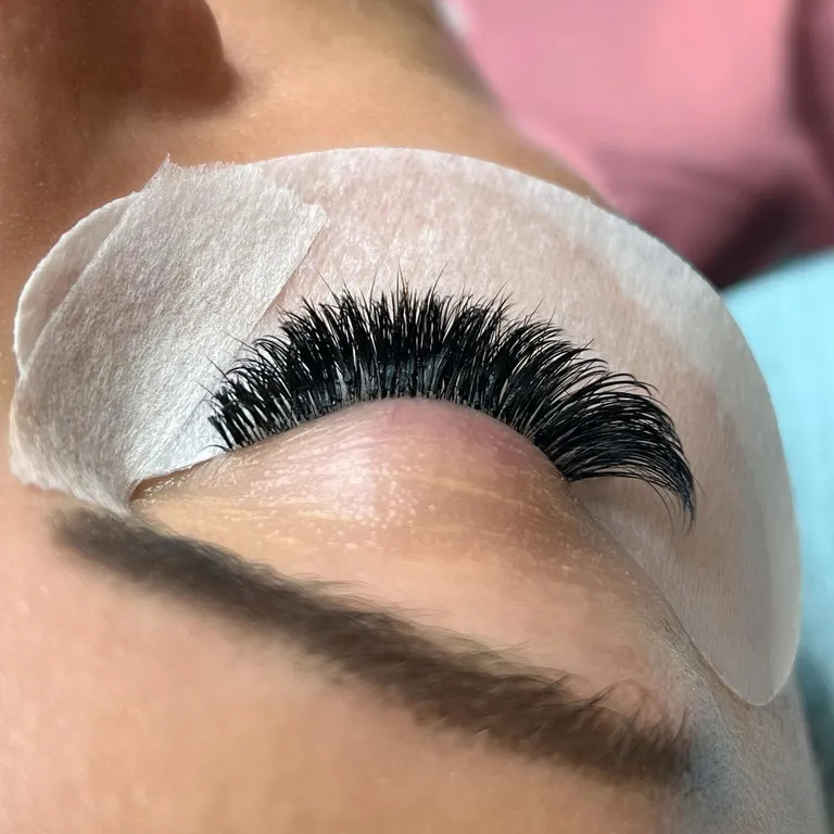 Close-up of a closed eye during a lash appointment showing dense handmade volume fans and a full outer corner by Made by Marissa.