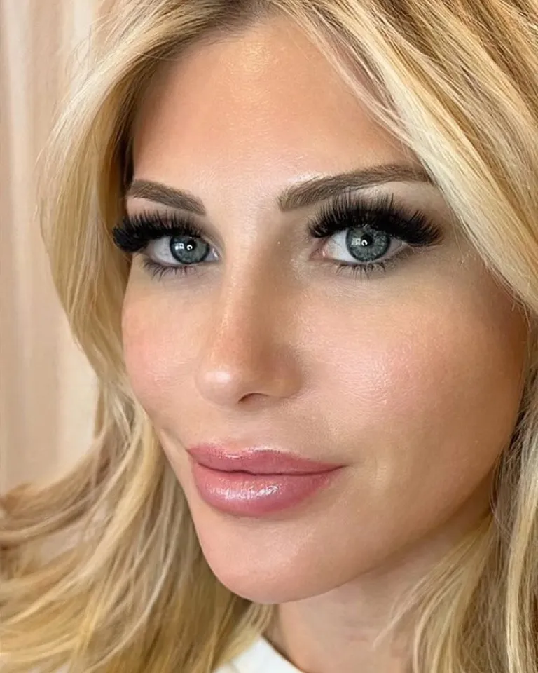 Portrait of a blonde, blue-eyed client wearing a dramatic full volume eyelash extension set with bold black fans by Made by Marissa.