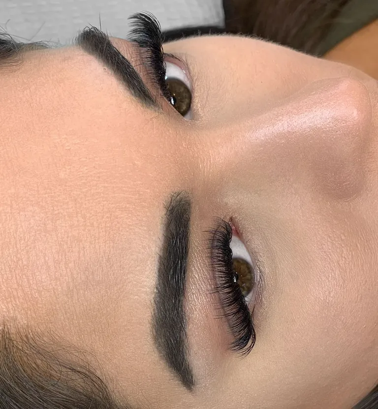 Angled close-up of both eyes wearing soft volume eyelash extensions with natural spacing and a gentle curl by Made by Marissa.