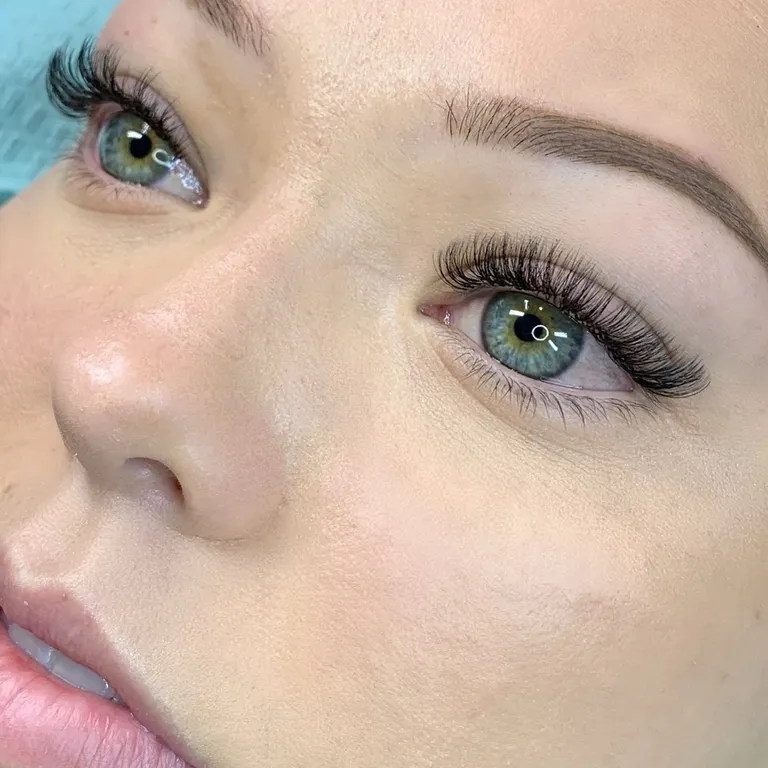 Close-up of blue-green eyes wearing an airy volume eyelash extension set with fine definition and subtle outer-corner length by Made by Marissa.
